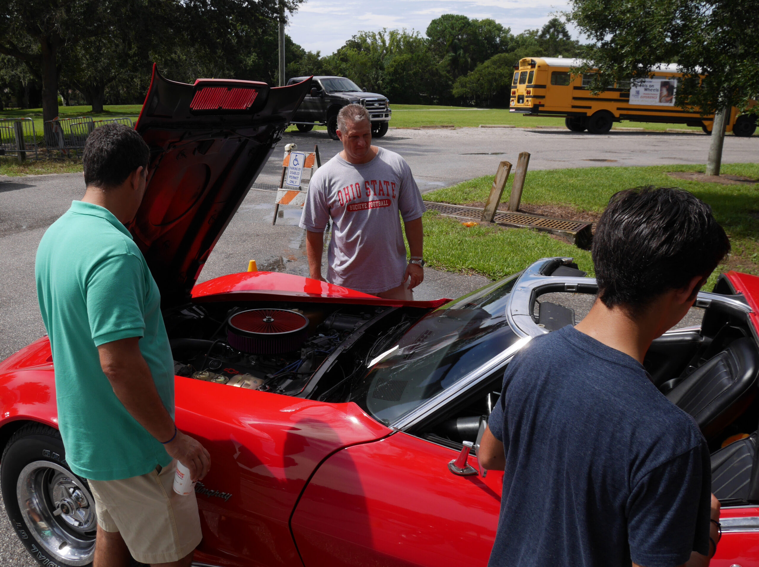 Spectators at Inagural Cars for Kids Car Show at DFAC with Wheels for Wheels bus in the background